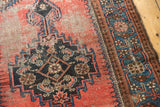 Vintage Kurdish Malayer rug's worn red field, showing navy Herati motifs and visible foundation.