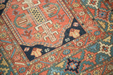 Antique Heriz rug detail: low pile, madder red field with navy and celadon geometric floral motifs.