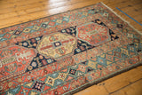 Antique Persian Heriz rug's unique celadon green border and red geometric field patterns.