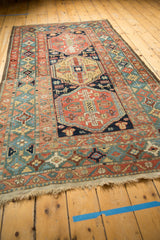 Antique Heriz rug's rare celadon green main border with intricate floral motifs and fringe.