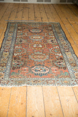 Distressed vintage Lilihan rug with intricate chestnut and sky blue floral palmettes, exhibiting aged texture.