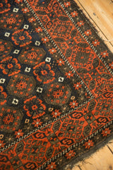 Intricate brick red starburst border on charcoal Belouch rug with low even pile.