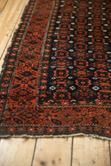 Antique Belouch runner detail: tattered end, goat hair selvage, and dark geometric starburst border.