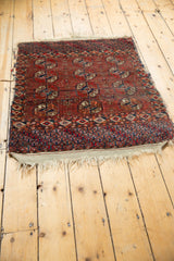 Antique Tekke rug corner showcasing geometric Bokhara gul motifs, varied pile, and fringed edge.