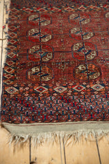 Antique Tekke rug border detail, geometric patterns in rich red, brown, blue, tattered fringe.