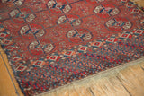 Antique Tekke rug with repeating geometric gul motifs, intricate multi-color border, and worn fringe.