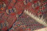 Antique Tekke rug's worn 'elephant footprint' gul, tattered fringe, and patterned reverse.