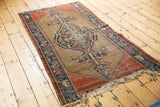 Lower end of antique Malayer rug, with cypress finial, madder red border, and aged camel ground.