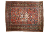 Antique Fereghan rug, madder red field, central ivory medallion, allover Herati pattern, aged pile wear.
