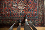 Antique Fereghan rug's madder red Herati motif and ivory medallion with celadon green wear.