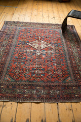 Secure end detail of antique Fereghan rug showing madder red and etched celadon green.