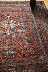 Antique Fereghan rug's madder red field, Herati motif, and aged celadon greens.