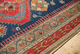 Detail of antique Caucasian rug's unusual scrolling stepped geometric border in red, indigo, and camel.