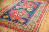 Antique Caucasian rug detail: serrated red medallion, indigo field, geometric camel border.