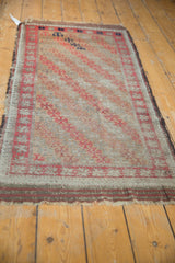 Antique Belouch rug corner, showing madder root brick red border, diagonal lattice, and recessed pile.