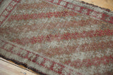 Antique Belouch runner detail, deeply worn pile with etched texture, brick red and ivory lattice.