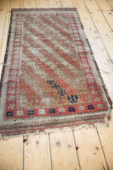 Antique Belouch rug's plain woven ends and geometric madder red, navy border.