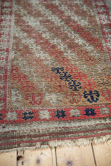 Fringed end of antique Belouch runner with low pile and unique navy geometric motifs.