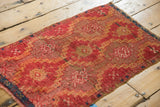 Geometric medallions and etched low pile on antique Turkish Yastik rug mat in ruby red and saffron yellow.