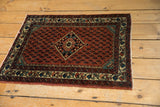 Angled view of a vintage Engelas rug, highlighting its central diamond medallion and rich boteh field.