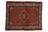 Vintage Persian Engelas rug mat with a navy diamond medallion on a red field of boteh motifs.