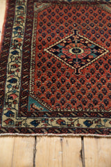 Corner detail of a vintage Persian rug showing its fine wool pile, boteh field, and geometric border.
