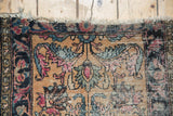 Antique Lilihan rug corner detail: tattered fringe, worn pile exposing foundation, floral motifs.