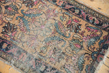 Expressive faded leaf motifs and foundational wear on a hand knotted antique Lilihan rug.