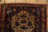 Intricate pinwheel and stylized floral motifs on the antique ivory field of a collector Afshar rug.