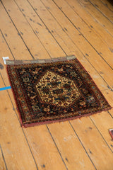 Hand-knotted edge of antique Afshar mat with rich navy, ivory, and wine red floral patterns.