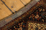 Antique Afshar rug corner detail with rich navy, red, ivory geometric borders and woven edge.