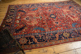 Antique Heriz carpet with its cherry red field, oversize scrolling serrated leaf and geometric motifs.