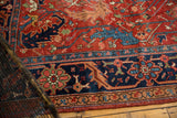 Detail of antique Heriz carpet, cherry red field with navy blue serrated leaf motifs.