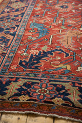 Cherry red field with navy blue geometric serrated leaf motif on antique Heriz carpet.