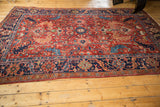 Detailed corner of antique Heriz carpet with navy blue geometric borders and cherry red field.