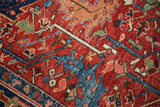 Antique Heriz rug detail: richly colored cherry red field, navy blue scrolling leaf motifs.
