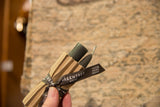 Antique color beeswax tapers, showing 100% pure beeswax ribbon on corrugated packaging.