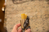 A hand holding a pair of natural beeswax tapers in their Greentree Home branded packaging.