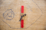 Pair of hand-poured coral beeswax taper candles wrapped in brown paper and black ribbon.