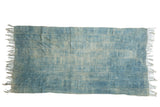 Aged hand woven African indigo textile throw featuring blue horizontal bands and fringe.