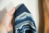 Close-up of a natural split on the vintage hand woven striped indigo textile.