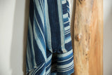 Close-up of hand-woven vintage indigo textile showing varied blue stripes and natural texture.