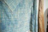 Textured blue and off-white handwoven African indigo textile with horizontal seams and fringe.