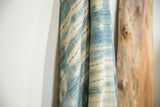 Folded vintage African indigo textile showcasing handwoven cotton texture and irregular dye patterns.