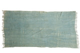 Hand-woven vintage African indigo textile throw, rich denim blue with varied tones, fringed.