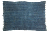 Hand-woven denim indigo African textile featuring stitched panels and textured blue variations.