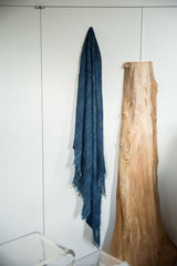 Draped vintage denim indigo African textile, highlighting hand-woven texture and fringed edges.