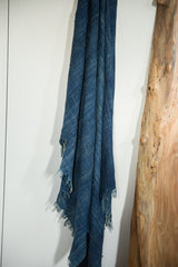 Draped vintage African indigo textile, revealing variegated hand-woven texture and fringed ends.