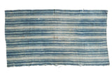 Hand woven vintage African indigo textile throw featuring organic blue and cream stripes.