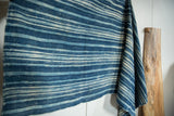 Vintage indigo African textile with softly draped, handwoven texture and varied blue stripes.